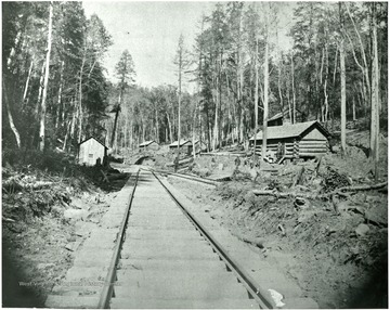 Miners log cabins built up next to the railroad.