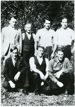 'Top Row. On left in light suit Fred Mooney; Next, the little man, our Dad, Watt Mooney; Next to Dad, me, John Mooney; far right standing Earl Mooney. Bottom Row. Left, Ira Mooney, center, Earnest Mooney, Right Rufus Mooney; all sons of Watt Mooney and brother to Fred Mooney. One brother missing, Oather Mooney. You will find him in other pictures. 