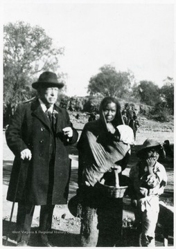 Portrait of Samuel Gompers in Mexico standing with a mother with children.