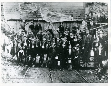 Miners and horses at Acme Mine on Cabin Creek posed for a group portrait.