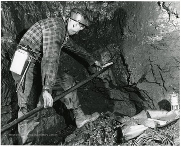 A miner at work placing a charge.