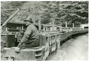 One man drives an electric locomotive that transports the miners out of the mine.