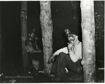 Miners take a break from placing timber that helps support the roof.