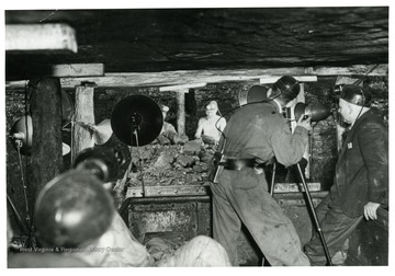 'Scene from a coal mine 300 ft. under a mountain in W. Va., where W.E. Austin, movie cameraman for the Norfolk and Western Railway is shown taking what are believed to be first color movies inside a mine.'
