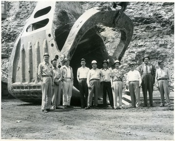 Group of men stand in front of a giant shovel scoop in Cleveland, OH.