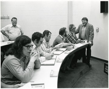 A group of men sit around a table.