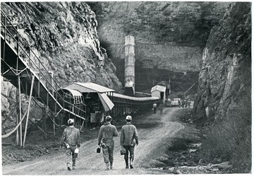A photo of three men walking to the mines.  