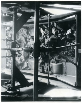 'Coal at all White Oak shaft mines is handled on self dumping cages, which handle coal uniformly and with a minimum of breakage. Note how evenly the coal is flowing from the mine car. Much more rapid course than the picture indicates, but it shows how well designed the equipment must be to handle the coal in such a splendid manner.'