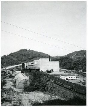 Large preparation plant with filled coal cars lining the outside.