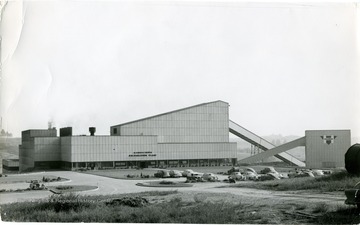 View of the entire plant with some cars and a motorcycle parked out front. 'Noted Oct 17, 1952, J.B.F.'