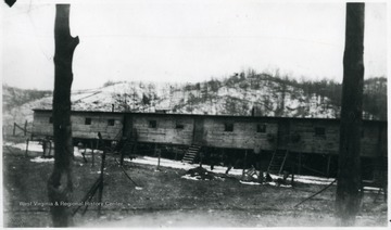 Front view of barracks at Grant Town, W. Va. Snow on hillside in background.