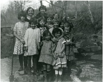 Picture presents unidentified girls near a creek.