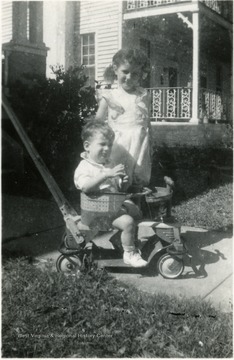 Helen Digit (standing) and John Digit III at 2 years old(sitting on a riding toy), Children of Luella Digit, Director of the Settlement House, 1936-1938.