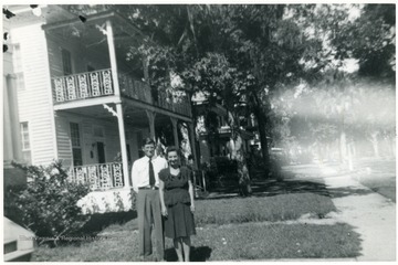 Luella Digit (worker at Scott's Run) and husband standing in yard of house 1936-1938.