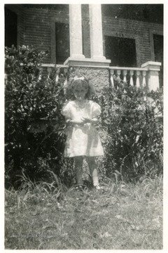 Helen Digit (Age Five), Luella Digit's daughter standing in front of a building with the number 504 above the door. 