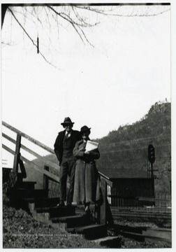 Couple poses for a picture on a set of steps.