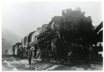 Freight train with man standing to the side.