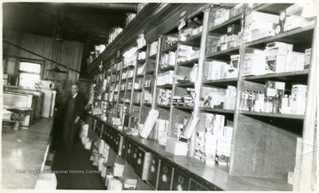 Shelves with stocked store merchandise. Mr. Guinn is standing in the background of the picture.