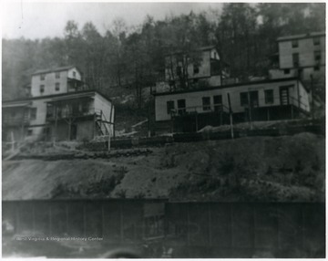 Miner's homes on a hillside above train cars. 'For more information on Mountaineer Mining Mission see A&amp;M 2491 (S.C.)'