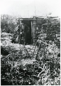 Man standing in doorway to old house.
