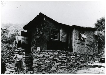 Picture of two men standing in front of a house.