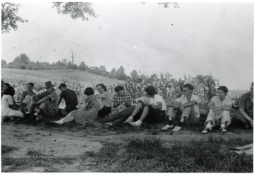 A group sitting on the outskirts of a garden, possibly American Friends Service Committee workers.