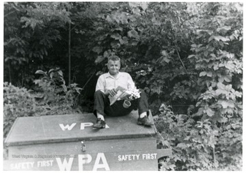 Pete Viola sitting on a wooden box with lid.