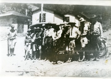 Group portrait of members of the Mingo County militia flying squad in front of an automobile. 'Pix used on page 58 of book.'