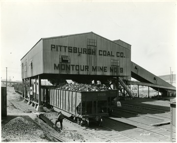 Pittsburgh Coal Co. Tipple loading a coal car.  Man standing near the tipple.