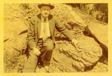 Unidentified man pointing to rock feature.