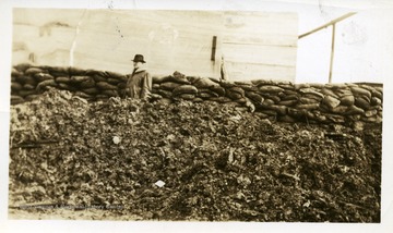Man standing in front of sandbags at the Wasson air shaft.