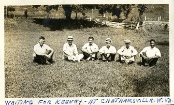 Six men sitting on the ground 'waiting for Keeney - at Chathamsville, W.Va.' Photograph from Joe Ozanic scrapbook.