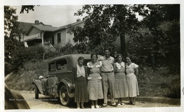 Four women and one man standing behind a car. Photograph from Joe Ozanic scrapbook.