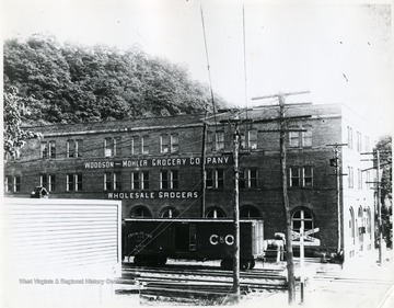 Frontal view of the Woodson - Mohler Grocery Co. Wholesale Grocers building in Alderson W. Va. with C&amp;O boxcar situated in front of building.