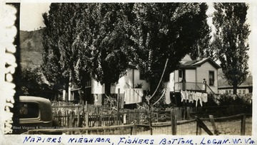 Clothes hang on a line in front of a home at Fishers Bottom in Logan, W. Va. Photograph from Joe Ozanic scrapbook.