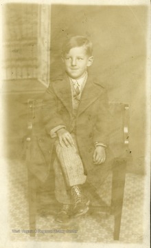 Portrait of a young boy sitting in a chair. 
