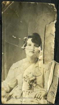 Woman sitting down for a portrait with a bouquet of flowers. 