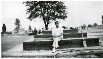 'Chairman of Committee, seated on foundation of Jones Memorial, Miners Cemetery, Mt. Olive, Ill.' 