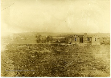 Truck with a pully system attached is sitting next the house.