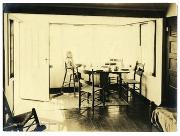 Little girl sitting in a breakfast nook in a house in Arthurdale.
