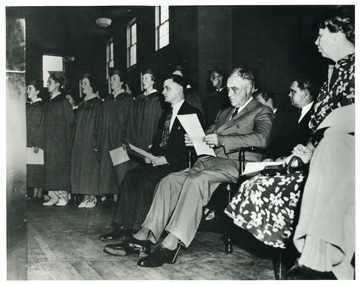 'President F.D. Roosevelt is listening to the graduating class of Arthurdale High School singing. On the left is E. Grant Nine, principal of the High School.' Eleanor Roosevelt 