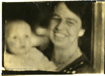Blurry view of Eleanor Roosevelt and a baby. 'Eleanor Roosevelt makes talkies for farewell speech.'