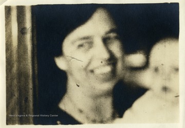 Blurry image of Eleanor Roosevelt and a baby. 'Mrs. Eleanor Roosevelt makes talkies for farewell speech.'