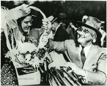 Franklin D. Roosevelt accepting flowerbasket from a high school graduate in Arthurdale W. Va. 'A print from the FDR Library Collection. this print is furnished for your file and must not be reproduced without the owner's permission. Owner: UPI (Acme).'