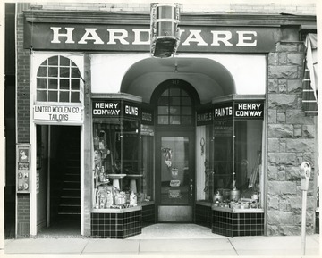 Hardware store next to United Woolen Co., Tailors. 'Copyrighted 1955, All Rights Reserved by Harlow Warren, 320 North Kanawha st., Beckley, W. Va.'