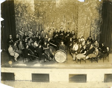 Group portrait of members of the Town District High School Band - Orchestra of Beckley, West Virginia on stage for a concert.