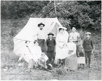 Lockard family poses for a picture next to their white camp tent.