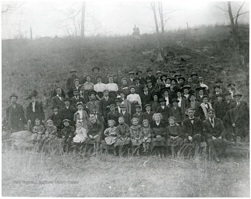Students and parents lined up in a field for a group portrait.
