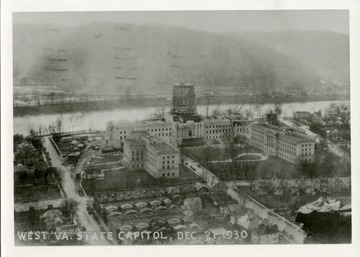 Postcard of the West Virginia State Capitol Building under construction.  The wings and main building are nearing completion, while the dome is stil a wooden frame.