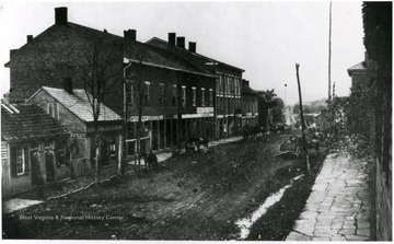 View of unpaved streets, stone sidewalks, and old buildings that lined Main Street in Clarksburg in 1863.